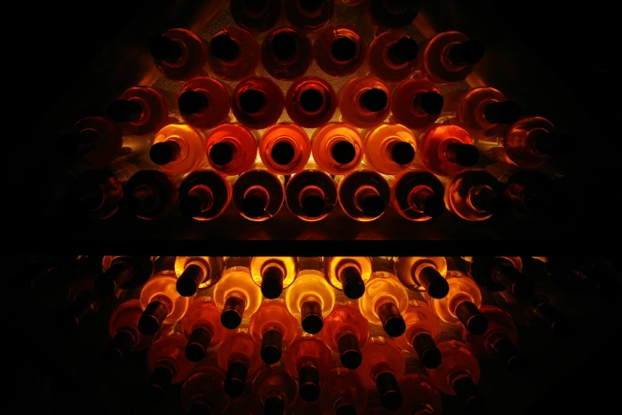Wine bottles displayed, gleaming in the darkness.